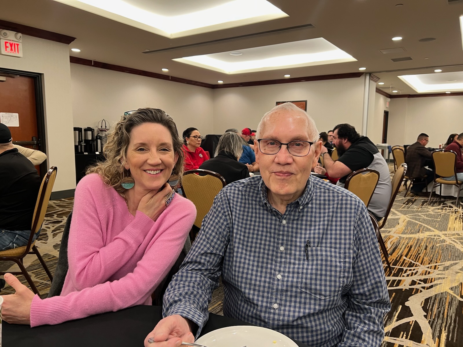 Charmagne in a pink sweater seated beside her father, Bob Gauthier